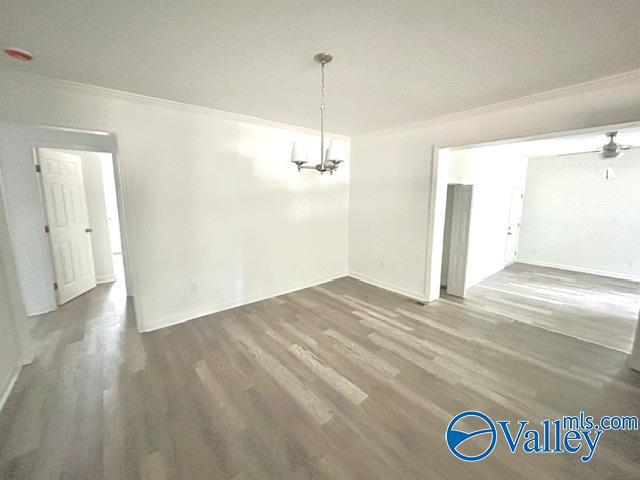 2618 NW Mountain Park Cir, Huntsville, AL 35810 - unfurnished dining area with a chandelier, wood finished floors, ornamental molding, and a ceiling fan