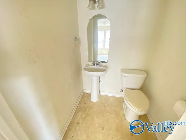 bathroom featuring toilet and baseboards