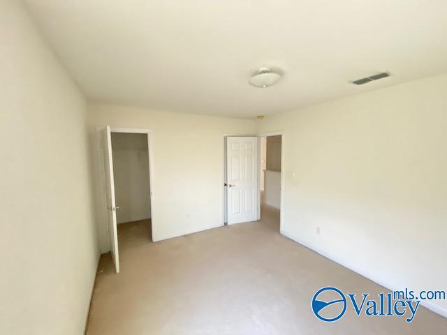 unfurnished bedroom featuring visible vents and a walk in closet