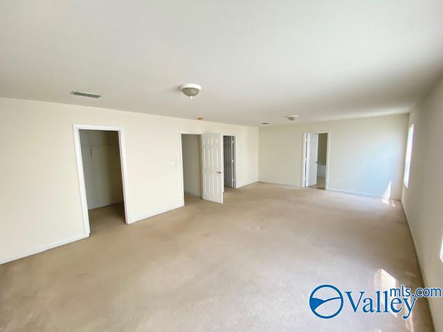 unfurnished room featuring light colored carpet and visible vents