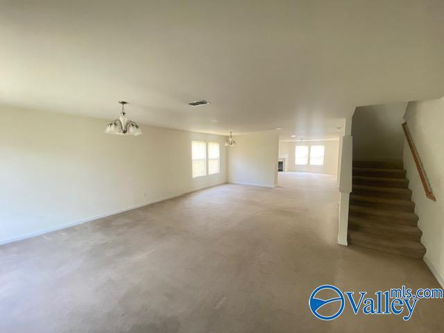 below grade area featuring stairs, visible vents, and a notable chandelier