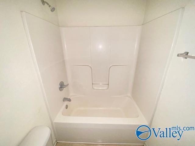 full bathroom featuring  shower combination and toilet