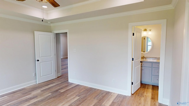 13680 Grigsby Ferry Rd, Elkmont, AL 35620 - unfurnished bedroom featuring light wood-style flooring, crown molding, baseboards, a tray ceiling, and a sink