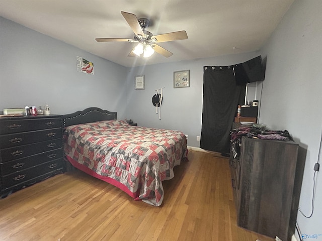 bedroom with a ceiling fan and light wood-style flooring