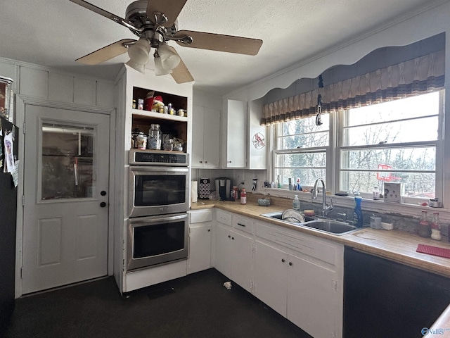 kitchen featuring double oven, a sink, white cabinets, light countertops, and open shelves