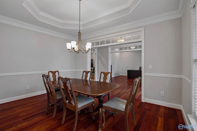 dining room with dark wood-style flooring, crown molding, a raised ceiling, a chandelier, and baseboards