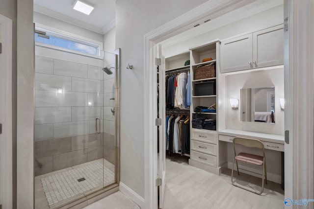 full bath with a shower stall, baseboards, a walk in closet, and crown molding