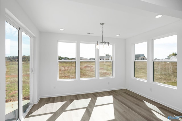 unfurnished dining area featuring dark hardwood / wood-style flooring and a notable chandelier