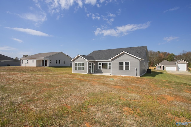 rear view of property with a garage and a lawn