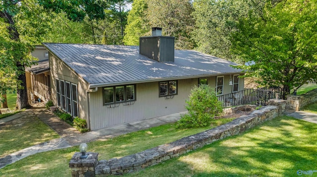 rear view of property with a lawn