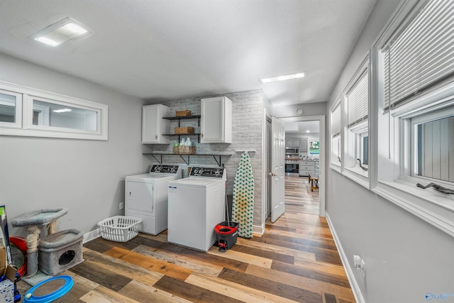 laundry room with washing machine and dryer, cabinets, and dark hardwood / wood-style flooring