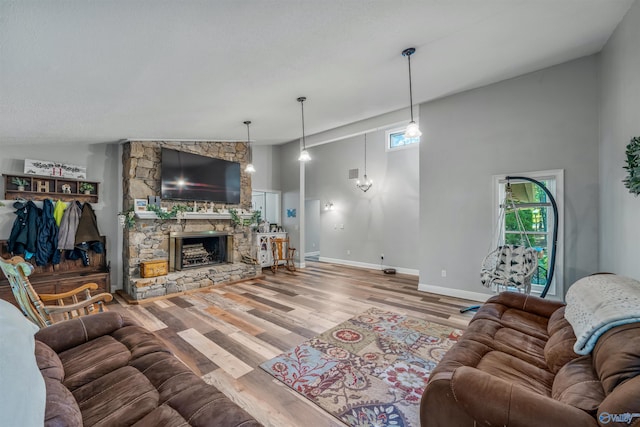 living room featuring high vaulted ceiling, a fireplace, and wood-type flooring