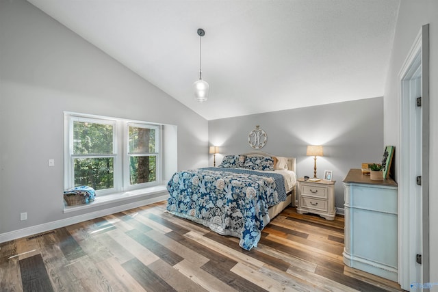 bedroom with high vaulted ceiling and hardwood / wood-style floors