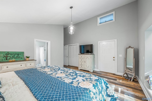 bedroom featuring high vaulted ceiling and hardwood / wood-style floors