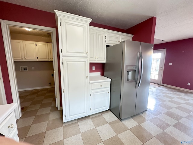 203 Lincoln Ave, Muscle Shoals, AL 35661 - kitchen featuring stainless steel refrigerator with ice dispenser, light flooring, white cabinets, baseboards, and a textured ceiling