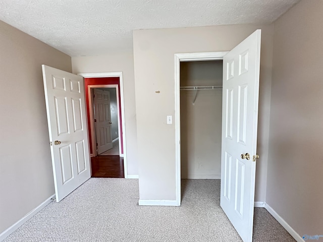 203 Lincoln Ave, Muscle Shoals, AL 35661 - unfurnished bedroom featuring carpet floors, baseboards, a closet, and a textured ceiling