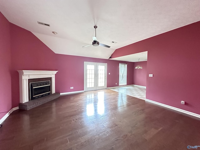203 Lincoln Ave, Muscle Shoals, AL 35661 - unfurnished living room with vaulted ceiling, ceiling fan, baseboards, a brick fireplace, and wood finished floors