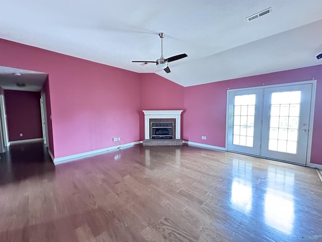 203 Lincoln Ave, Muscle Shoals, AL 35661 - unfurnished living room with baseboards, lofted ceiling, a ceiling fan, a brick fireplace, and wood finished floors
