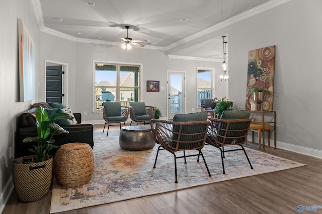 living area with ornamental molding, baseboards, and wood finished floors