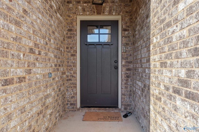 view of exterior entry featuring brick siding