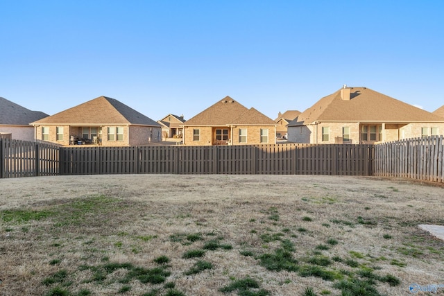 view of yard featuring a fenced backyard and a residential view