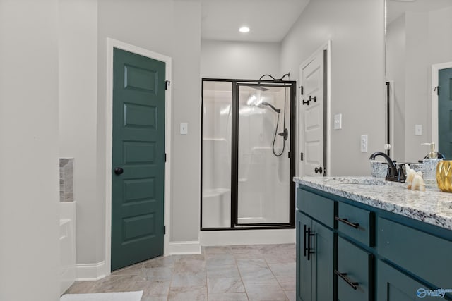 bathroom featuring baseboards, vanity, and a shower stall