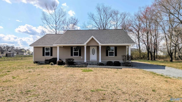 ranch-style home with a porch, a front yard, and roof with shingles