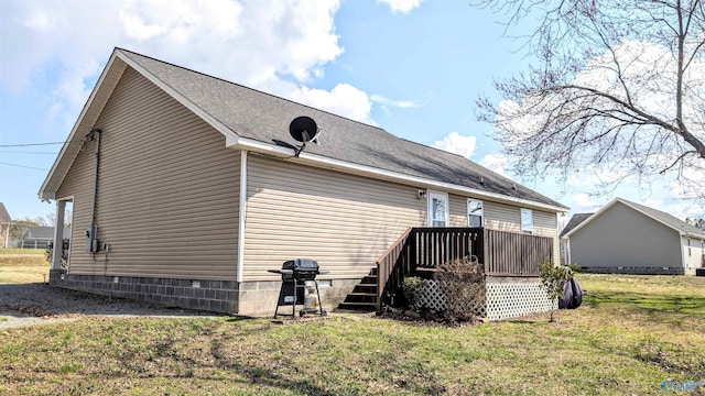 rear view of property with a yard, roof with shingles, and a deck