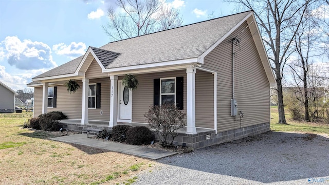 view of front of house featuring a porch, a front lawn, and a shingled roof