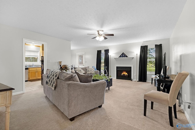 14249 Parker Rd, Athens, AL 35611 - living area featuring ceiling fan, light colored carpet, healthy amount of natural light, a warm lit fireplace, and a textured ceiling