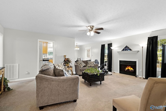 14249 Parker Rd, Athens, AL 35611 - living room featuring light carpet, a ceiling fan, a fireplace with flush hearth, baseboards, and a textured ceiling