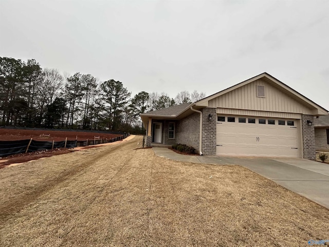 view of front of home featuring a front lawn, brick siding, driveway, and an attached garage