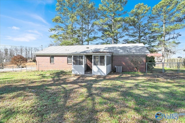 back of house featuring a lawn and central air condition unit