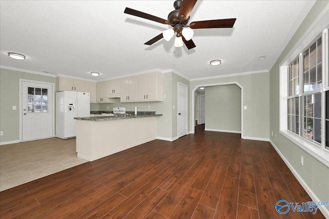 kitchen with crown molding, a textured ceiling, dark hardwood / wood-style floors, kitchen peninsula, and white fridge with ice dispenser