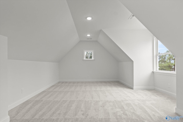 bonus room featuring light carpet, plenty of natural light, and lofted ceiling