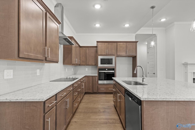 kitchen featuring pendant lighting, sink, stainless steel appliances, light stone countertops, and wall chimney range hood