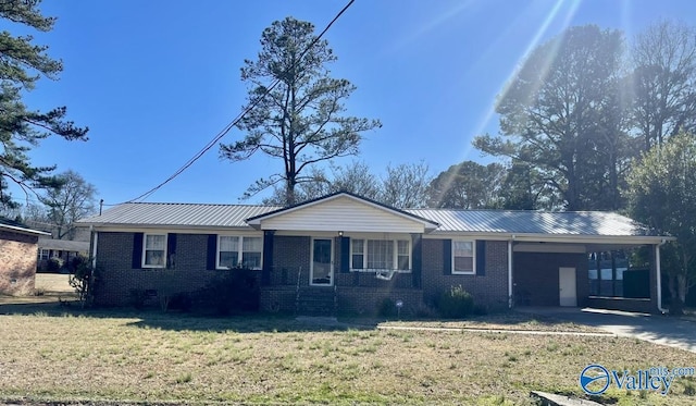 ranch-style house with metal roof, an attached carport, brick siding, concrete driveway, and a front lawn