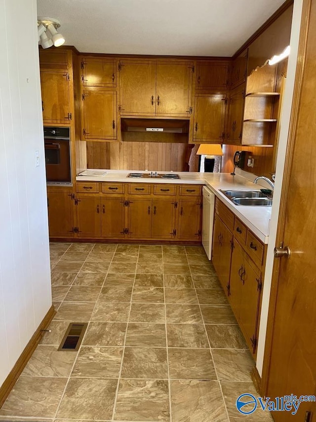 kitchen featuring wall oven, cooktop, visible vents, open shelves, and a sink