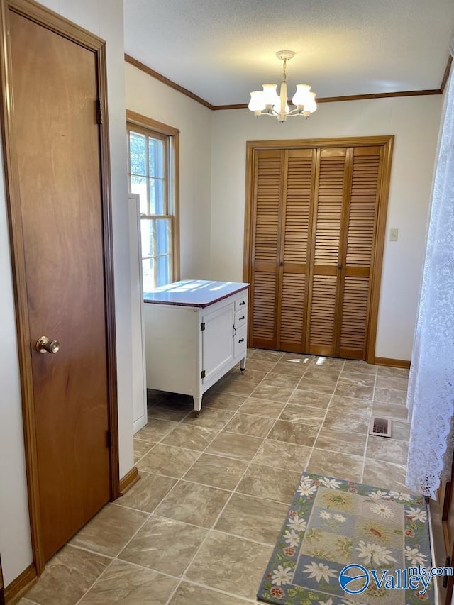 interior space featuring ornamental molding, a chandelier, visible vents, and baseboards