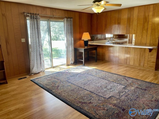 kitchen with a healthy amount of sunlight, visible vents, brown cabinetry, and wood finished floors