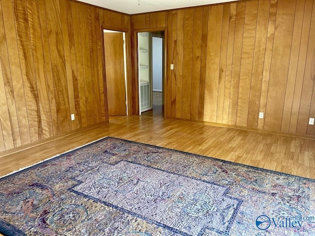 empty room with wood walls and wood finished floors