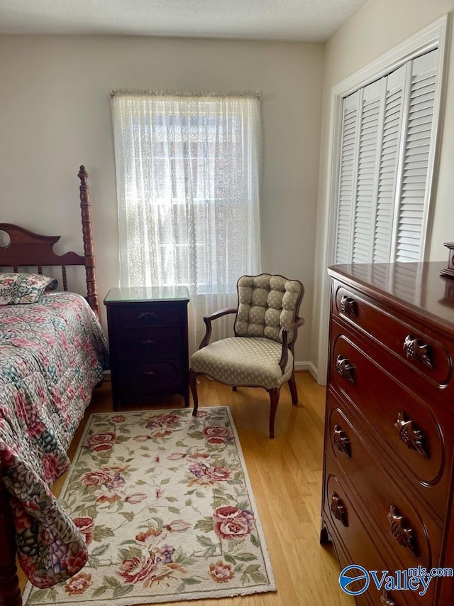 bedroom with light wood finished floors and multiple windows