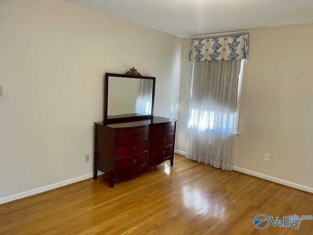 bedroom featuring baseboards and wood finished floors