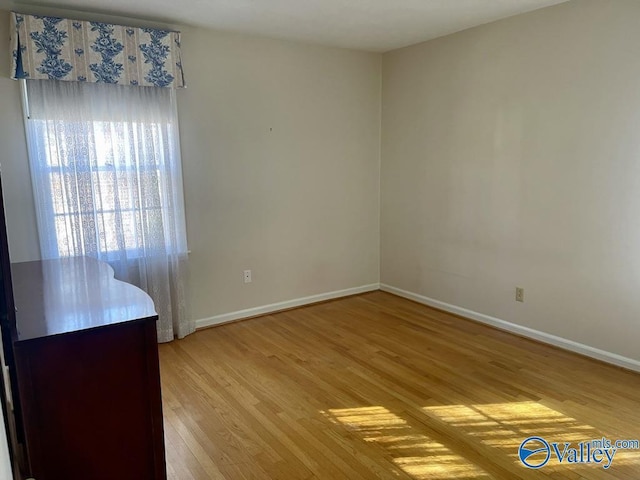 empty room with light wood finished floors and baseboards