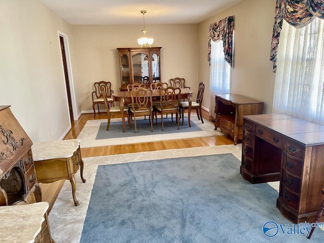 dining space featuring light wood-type flooring, a wealth of natural light, and baseboards