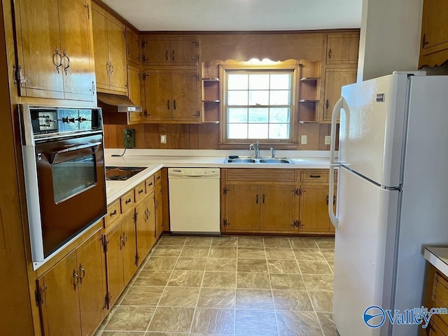 kitchen with under cabinet range hood, white appliances, a sink, light countertops, and open shelves