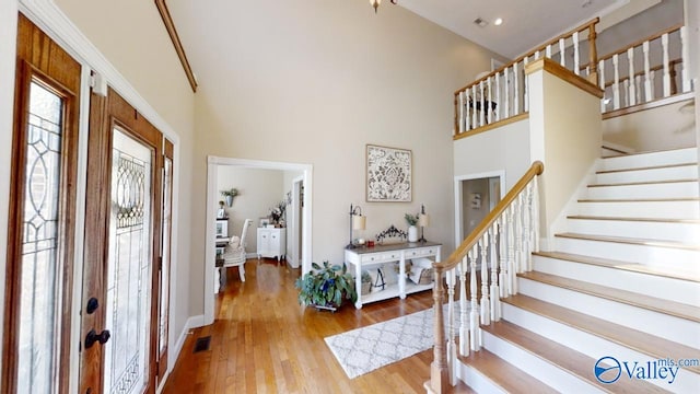 foyer entrance with a high ceiling and wood-type flooring