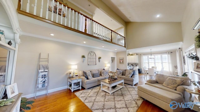 living room with ornamental molding, high vaulted ceiling, and light hardwood / wood-style floors