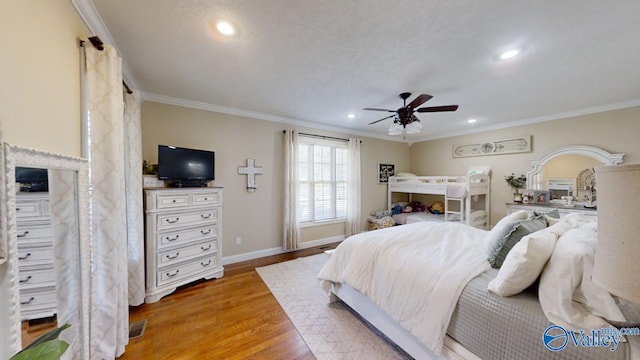 bedroom featuring light wood-type flooring, ceiling fan, and ornamental molding