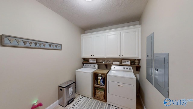 laundry room featuring washer and dryer, cabinets, electric panel, and a textured ceiling